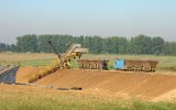In der Tongrube arbeitet ein kleiner Eimerkettenbagger mit bemerkenswerten Schutzgittern ber den beweglichen Teilen des Antriebs und der Eimerkette (09. Mai 2000)