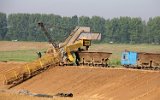 In der Tongrube arbeitet ein kleiner Eimerkettenbagger mit bemerkenswerten Schutzgittern ber den beweglichen Teilen des Antriebs und der Eimerkette (09. Mai 2000)